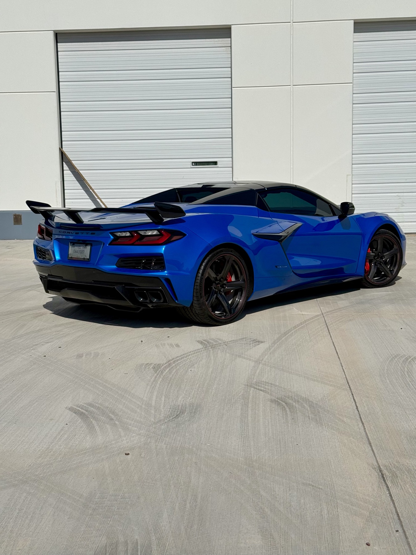 Blue Corvette Z06 rear with carbon wing — glossy protected finish