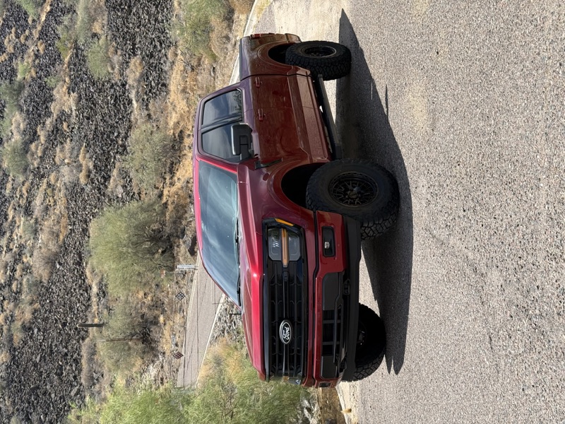 Red Ford F-150 lifted on a desert road