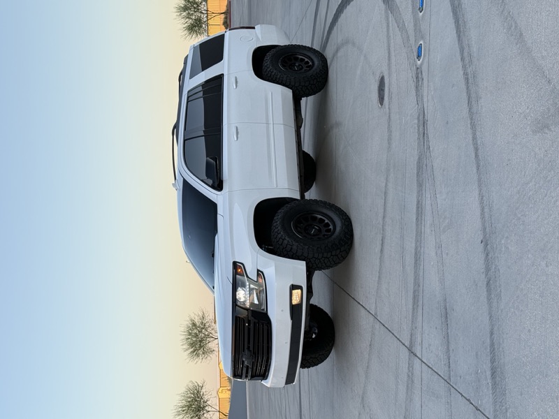 White Chevy Tahoe lifted at golden hour