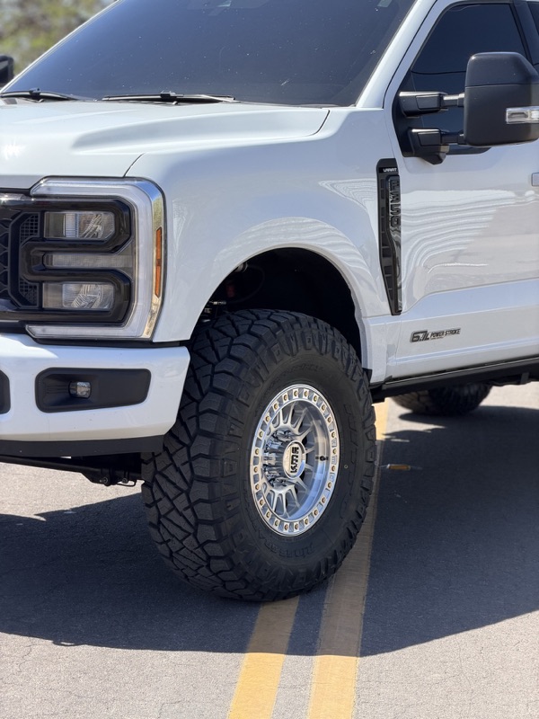 Lifted F-250 fender with forged wheel and mud-terrain tire